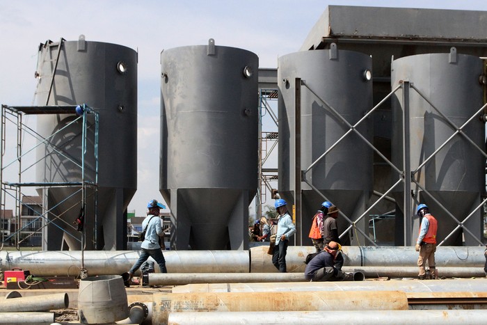 Pekerja menyambungkan pipa besi pada proyek instalasi pengolahan air minum atau Water Treatment Plant (WTP) di Pandanwangi, Malang, Jawa Timur, Jumat (8/9/2023). Proyek kerjasama tiga pihak yakni Pemkot Malang, Perum Jasa Tirta I dan Perumda Tugu Tirta dengan nilai investasi sebesar Rp74 miliar tersebut memanfaatkan air sungai Bango untuk diolah menjadi air minum dengan kapasitas sebesar 200 lps (liter per second) serta ditargetkan rampung pada akhir tahun 2023. ANTARA FOTO/Ari Bowo Sucipto/nym.