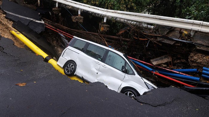 Hujan deras dan tanah longsor melanda Hong Kong, Jumat (8/9/2023). Bahkan sebuah mobil terperosok karena jalan yang dilalui longsor.