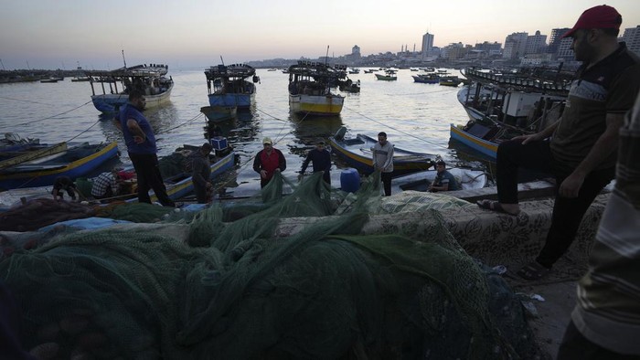 Nelayan Gaza Minta Israel Cabut Larangan Ekspor Palestinian fishermen pull fishing nets into their trawlers at the seaport in Gaza City, Thursday, Sept. 7, 2023. After allegedly uncovering explosives hidden in clothing shipped from Gaza to the West Bank, the Israeli government opted for a punitive response this week, clamping down on all cargo shipments out of Gaza and choking off the territory's already ailing economy. (AP Photo/Adel Hana)