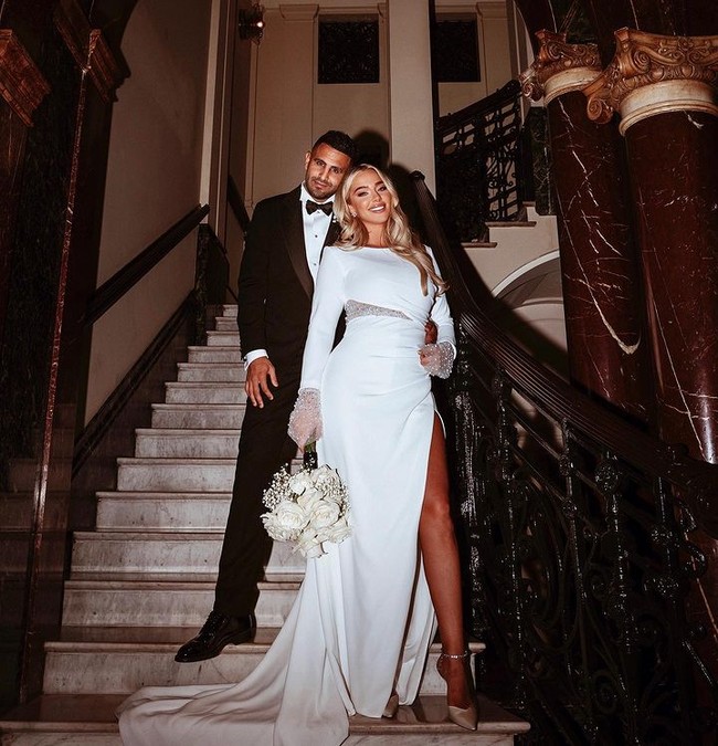 Dalam foto yang dibagikan, Taylor terlihat tampak mengenakan setelan tuxedo sedangkan istrinya memakai long dress putih dengan aksen belahan dan material transparan yang menonjolkan bentuk tubuhnya. Foto: Instagram