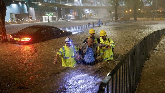 Drainage workers assist a driver stranded due to flooding to a safe place, during heavy rain in Hong Kong, China September 8, 2023. REUTERS/Tyrone Siu