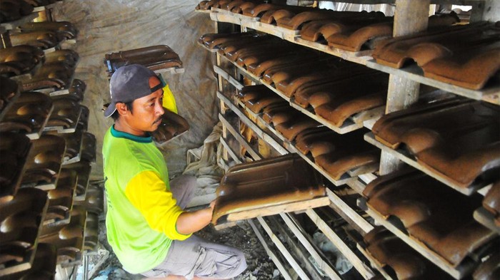 Perajin menyelesaikan pembuatan genting jenis Sokka di sentra industri pembuatan genting Desa Ngembal Kulon, Jati, Kudus, Jawa Tengah, Jumat (8/9/2023). Genting berbahan tanah liat yang dibuat secara tradisional yang dijual Rp1.000 hingga Rp1.300 per buah yang dipasarkan ke wilayah Jawa Tengah itu menjadi urat nadi perekonomian di desa itu yang banyak memperkerjakan tenaga kerja dari luar desa. ANTARA FOTO/Yusuf Nugroho