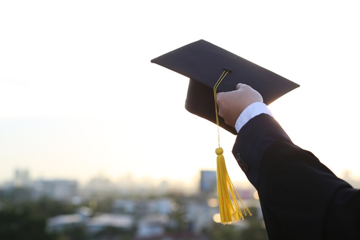 A picture of a man holding a graduation hat