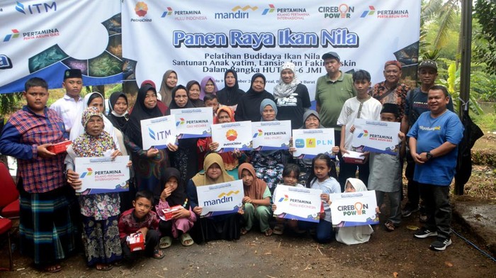 Vietor Heglind Tobing  Sr. Analyst II PT Perusahaan Gas Negara Tbk (kanan) bersama anggota Jurnalis Mancing Indonesia (JMI) panen ikan nila merah hasil budidaya ikan sistem bioflok di JMI Jago, Bilabong, Bogor, Sabtu (9/9/2023).