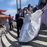 Gaun dari koleksi Monica Ivena ini minim detail namun tetap terlihat megah berkat hiasan bordir serta ekor panjang dan lebar. Foto: Instagram/@pammybowie