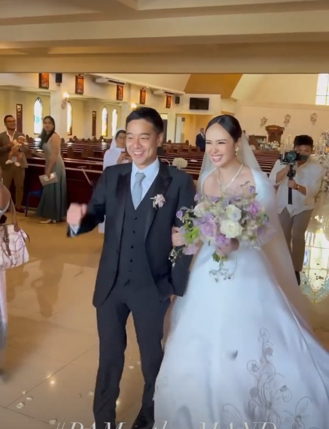 Aktris Pamela Bowie memilih gaun pengantin klasik berpotongan A-line dengan garis leher square. Foto: Instagram/@pammybowie