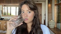 Di Sumba, Aurelie pamer momen minum air putih. Kulitnya terlihat sehat karena sepertinya terhidrasi dengan baik.