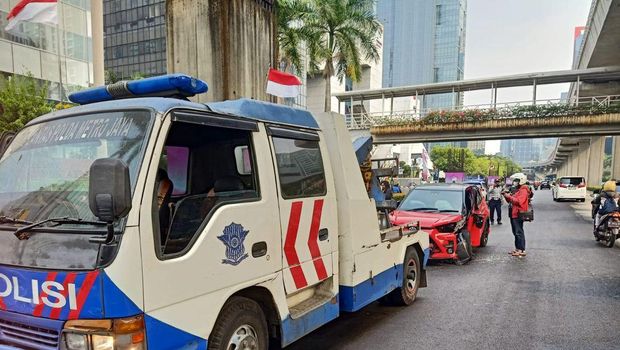 Satu unit mobil berwarna merah mengalami kecelakaan di Jalan HR Rasuna Said, Setiabudi, Jaksel. Mobil itu mengalami kerusakan pada bodi depan akibat kecelakaan. (IG TMC Polda Metro Jaya)