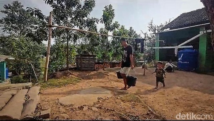 Warga Kelurahan Way Laga mengangkut air bersih.