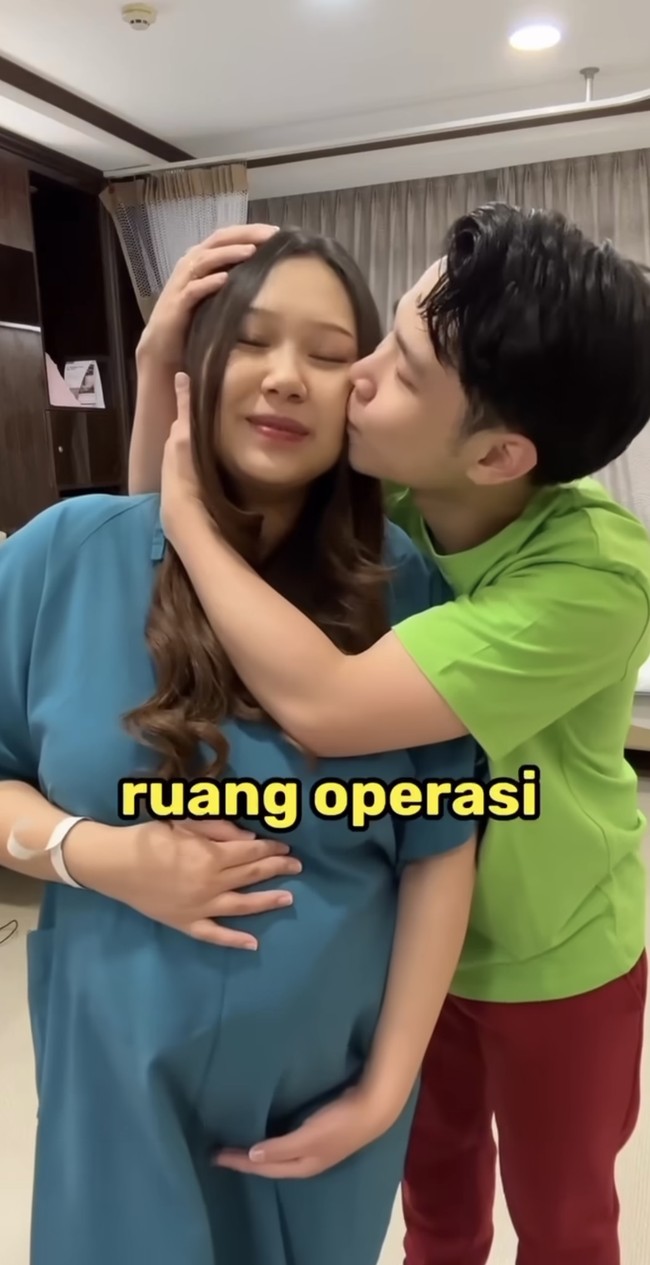 Tak hanya mengelus perut Sisca, Jess No Limit juga terlihat mencium pipi istrinya itu. Dalam keterangan video diketahui jika video tersebut diambil antara 10 hingga 20 menit sebelum masuk ke ruang operasi. Foto: Instagram/@jessnolimit