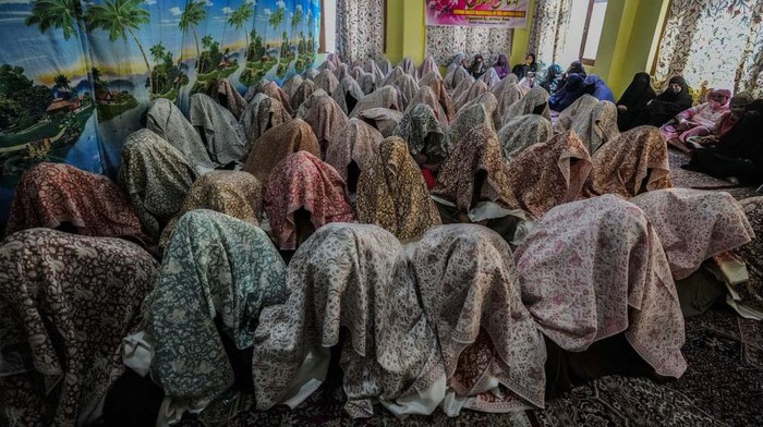 A Kashmiri Muslim bride holds her veil as she sits during a mass wedding event in Srinagar, Indian controlled Kashmir, Sunday, Sept 10, 2023. Mass weddings in India are organized by social organizations primarily to help the economically backward families who cannot afford the high ceremony costs as well as the customary dowry and expensive gifts that are still prevalent in many communities. (AP Photo/Mukhtar Khan)