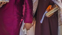 Pasangan pengantin baru berpegangan tangan saat berjalan saat acara pernikahan massal di Srinagar, Kashmir, Minggu 10 September 2023.  