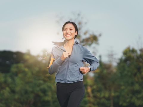 Healthy Asian woman is jogging outdoor. Fitness girl running. Female exercising at outdoor park.