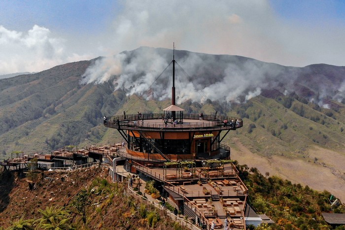 Foto udara kendaraan melintas di ruas jalan di kawasan Gunung Bromo, Lumajang, Jawa Timur, Sabtu (9/9/2023). Akibat kebakaran hutan dan lahan (karhutla) seluas 274 hektar yang terjadi di kawasan itu, Balai Besar Taman Nasional Bromo Tengger Semeru (BB TNBTS) menutup total aktivitas wisata di Gunung Bromo. ANTARA FOTO/Muhammad Mada/Spt.