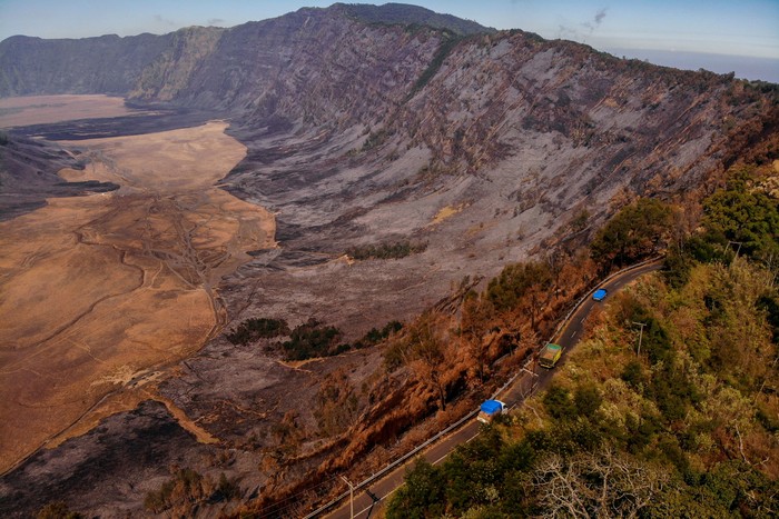 Foto udara kendaraan melintas di ruas jalan di kawasan Gunung Bromo, Lumajang, Jawa Timur, Sabtu (9/9/2023). Akibat kebakaran hutan dan lahan (karhutla) seluas 274 hektar yang terjadi di kawasan itu, Balai Besar Taman Nasional Bromo Tengger Semeru (BB TNBTS) menutup total aktivitas wisata di Gunung Bromo. ANTARA FOTO/Muhammad Mada/Spt.