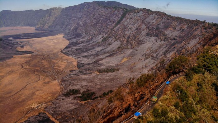 Foto udara kendaraan melintas di ruas jalan di kawasan Gunung Bromo, Lumajang, Jawa Timur, Sabtu (9/9/2023). Akibat kebakaran hutan dan lahan (karhutla) seluas 274 hektar yang terjadi di kawasan itu, Balai Besar Taman Nasional Bromo Tengger Semeru (BB TNBTS) menutup total aktivitas wisata di Gunung Bromo. ANTARA FOTO/Muhammad Mada/Spt.