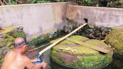 Salah seorang warga mengisi air di salah satu sumber mata air di Karangasem.