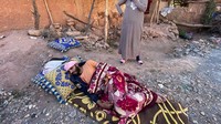 Warga yang terluka akibat gempa mengungsi di ruang terbuka sekitar rumahnya di Desa Tansghart. Dia tidur di tempat pengungsian itu hanya dengan beralaskan karpet. Reuters/Abdelhak Balhaki.  