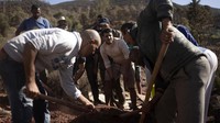 Warga menggali liang lahat untuk korban tewas akibat gempa bumi di Desa Ouargane, Maroko.  