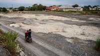 Pengendara sepeda motor melintas di kawasan pertambangan pasir rakyat yang terdampak kekeringan di Sungai Palupi, Palu, Sulawesi Tengah, Minggu (10/9/2023).  