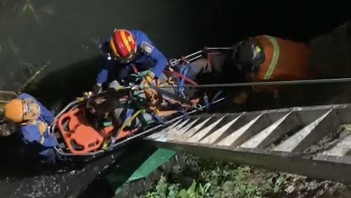 Petugas Damkar mengevakuasi driver ojol dan penumpangnya yang jatuh ke sungai