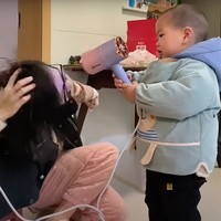 Mulai dari menyuapi ibunya makan, membantu mengeringkan rambut, hingga membersihkan rumah, semuanya bisa dikerjakan oleh Pomelo. Seperti yang terlihat dalam foto, saat Pomelo membantu memegang pengering rambut untuk ibunya. Foto: South China Morning Post