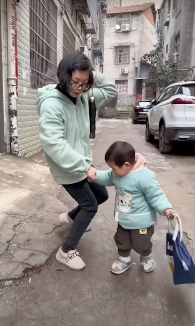 Ibu Pomelo diketahui terkena celebral palsy atau lumpuh otak. Hal itu menyebabkan pergerakan otot sang ibu jadi terbatas. Pomelo pun harus menuntunnya agar ibunya itu tidak terjatuh. Foto: South China Morning Post