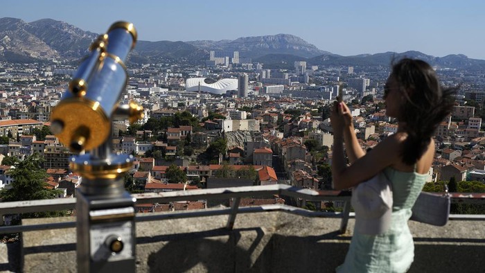 Men gesture as they visit the Notre Dame de la Garde Basilica's viewpoint in Marseille, France, Saturday, Sept. 9, 2023. (AP Photo/Pavel Golovkin)
