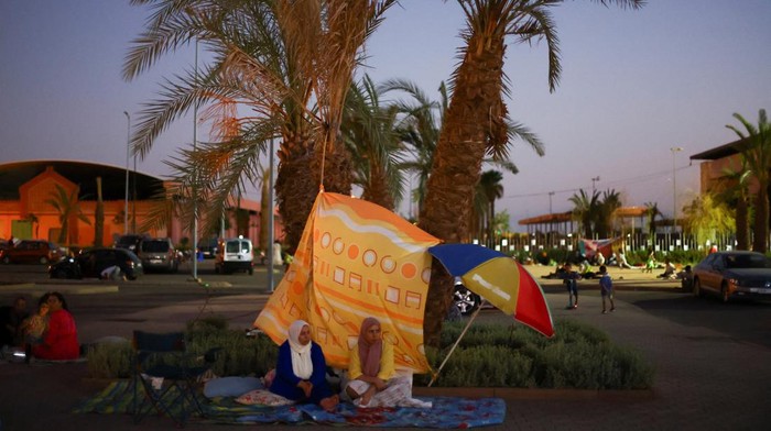 Saat Warga Maroko Tidur di Pinggir Jalan Khawatir Gempa Susulan People sit outside in Marrakech, following a powerful earthquake in Morocco, September 9, 2023. REUTERS/Hannah McKay
