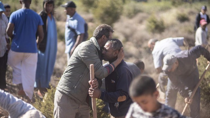 People comfort each other while digging graves for victims of the earthquake, in Ouargane village, near Marrakech, Morocco, Saturday, Sept. 9, 2023. A rare, powerful earthquake struck Morocco, sending people racing from their beds into the streets and toppling buildings in mountainous villages and ancient cities not built to withstand such force. (AP Photo/Mosa'ab Elshamy)
