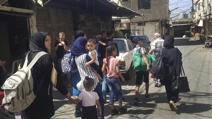 Terjadi Lagi! Bentrokan di Kamp Pengungsi Palestina di Lebanon Palestinian residents carry their belongings as they flee their home after clashes that erupted between members of the Palestinian Fatah group and Islamist militants in the Palestinian refugee camp of Ein el-Hilweh near the southern port city of Sidon, Friday, Sept. 8, 2023. Clashes resumed in Lebanon's largest Palestinian camp overnight, with heavy gunfire and shelling wounding several people and prompting residents of the camp and the surrounding area to flee Friday. (AP Photo/Mohammed Zaatari)