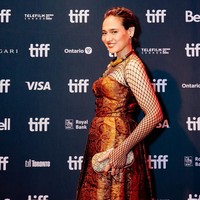 Ine Febriyanti mengenakan gaun dengan aksen jaring-jaring pada bagian dada hingga lengan. Gaun berpotongan A-line itu terbuat dari tenun berwarna emas. Foto: Instagram