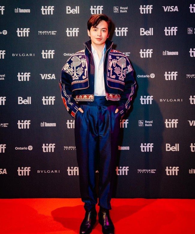 Angga Yunanda menambahkan statement gaya pada setelan kemeja dan celana dengan jaket biru motif tenun Sumba. Foto: Instagram