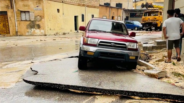 Jalanan di Libya Ambles Gegara Badai Dahsyat A view shows a damaged car on a broken road, after a powerful storm and heavy rainfall hit, in Al Bayda, Libya, September 11, 2023, in this screengrab obtained from social media video. Instagram/@EX5TWD via REUTERS. ATTENTION EDITORS - THIS IMAGE HAS BEEN SUPPLIED BY A THIRD PARTY. MANDATORY CREDIT. NO RESALES. NO ARCHIVES