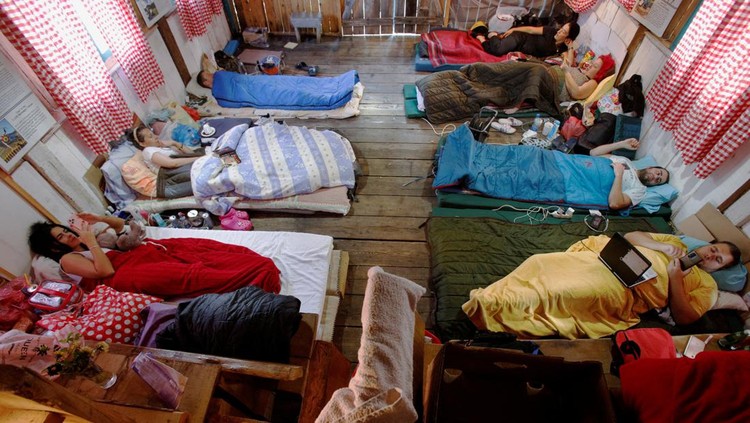 Participants lay inside a hut, as they participate in a satirical contest to mock a popular myth that labels Montenegrins as lazy people, in the village of Brezna, Pluzine, Montenegro, September 6, 2023. REUTERS/Stevo Vasiljevic     TPX IMAGES OF THE DAY