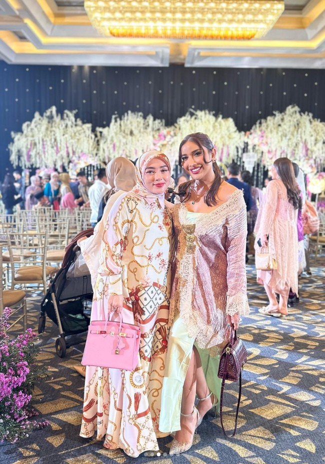 Millen tampil mengenakan dress panjang berwarna hijau tosca dipadukan dengan outer bernuansa merah muda dan ungu. Rambut panjangnya tampak simpel dengan hanya diikat satu ke belakang. Foto: Instagram/@millencyrus