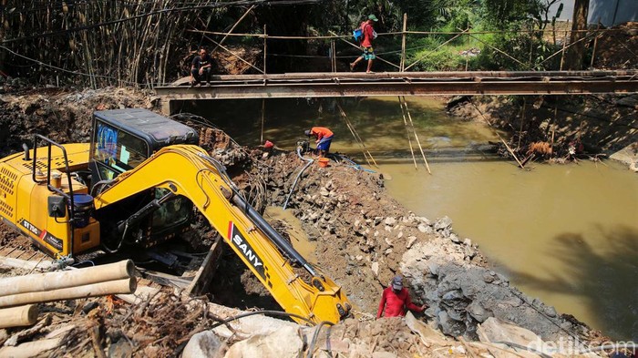 Sejumlah pekerja tengah melakukan pembuatan konstruksi jembatan di Jalan AMD, Tangerang Selatan, Selasa (12/9/2023). Pekerjaan peninggian jembatan di Kali Angke ini merupakan bagian dari pengendalian banjir.