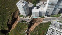 Gedung apartemen itu hampir runtuh karena tanah longsor yang disebabkan sebuah penampung air roboh akibat hujan lebat.