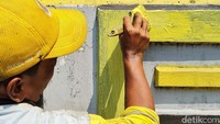 Petugas Bina Marga mengecat dengan warna kuning.  