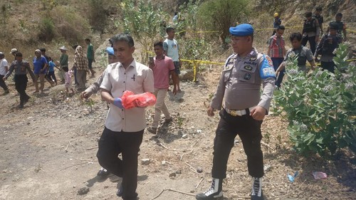 Polisi membawa jasad bayi yang ditemukan terkubur oleh warga.