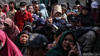Sebagian warga menjadi keranjang sebagai penutup kepala agar terhindar dari panas sinar matahari.  