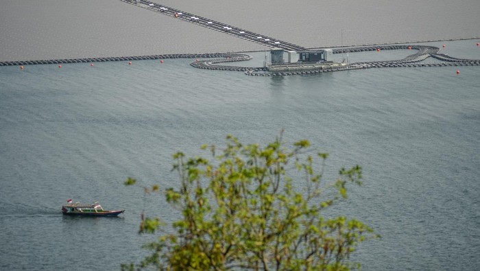 Proyek pembangunan PLTS terapung Waduk Cirata Perahu melintas di samping proyek Pembangkit Listrik Tenaga Surya (PLTS) terapung di Waduk Cirata, Kabupaten Cianjur, Jawa Barat, Selasa (12/9/2023). PLTS terapung di Waduk Cirata dengan kapasitas 192 megawatt peak (MWp) yang terbentang di area seluas 200 hektare serta terdiri lebih dari 340 ribu solar panel dan mampu memproduksi 245 juta kWh bersih per tahun tersebut rencananya akan diresmikan pada 2023 mendatang oleh Presiden Joko Widodo. ANTARA FOTO/Raisan Al Farisi/hp.
