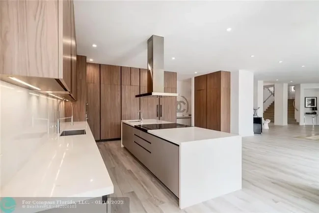 Desain yang modern menjalar hingga ke seluruh area rumah, termasuk dapur. Material kayu sebagai aksen menciptakan atmosfer yang hangat. (Foto: Dok. Compass Florida LLC)
