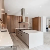 Desain yang modern menjalar hingga ke seluruh area rumah, termasuk dapur. Material kayu sebagai aksen menciptakan atmosfer yang hangat. (Foto: Dok. Compass Florida LLC)