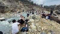 Pada foto yang diambil, Minggu (10/9/2023), tidak sedikit wisatawan yang bersantai di aliran sungai yang hangat ini. Mulai dari berfoto, menyelupkan kaki, bahkan sampai berendam. 