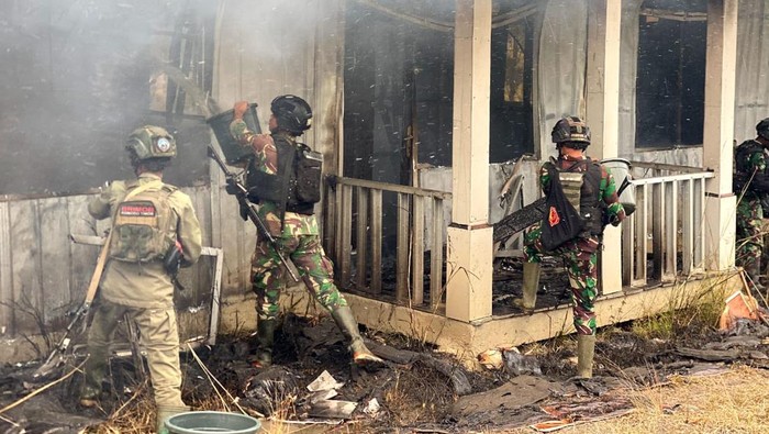Aparat TNI berusaha memadamkan api di perumahaan nakes yang dibakar KKB di Distrik Ilaga, Kabupaten Puncak, Papua Tengah.
