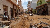 Lumpur yang terbawa arus banjir menyelimuti jalanan di Kota Derna. Selain itu, puing-puing yang terseret arus banjir juga menyangkut di sejumlah gedung. Reuters/Esam Omran Al-Fetori.