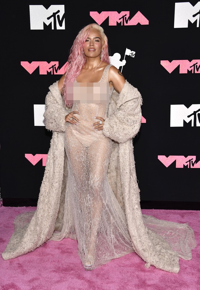 Penyanyi asal Kolombia Karol G pakai gaun menerawang yang dipadukan mantel berwarna senada. Tanpa aksen lain seperti aksesori, penampilannya terlihat monoton. Foto: Evan Agostini/Invision/AP