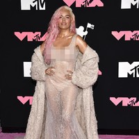 Penyanyi asal Kolombia Karol G pakai gaun menerawang yang dipadukan mantel berwarna senada. Tanpa aksen lain seperti aksesori, penampilannya terlihat monoton. Foto: Evan Agostini/Invision/AP