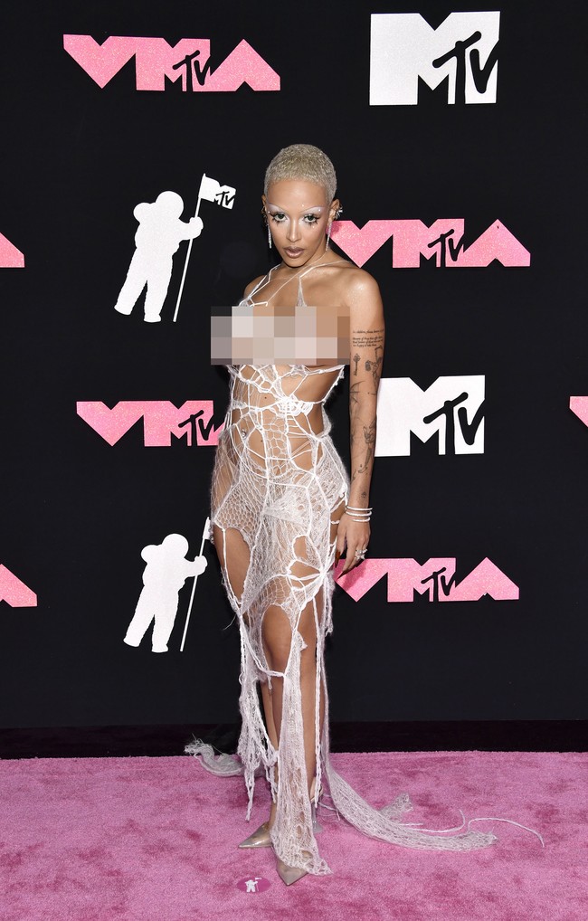 Doja Cat dengan gaya eksentriknya memakai gaun seperti sarang laba-laba yang sudah rusak. Foto: Evan Agostini/Invision/AP